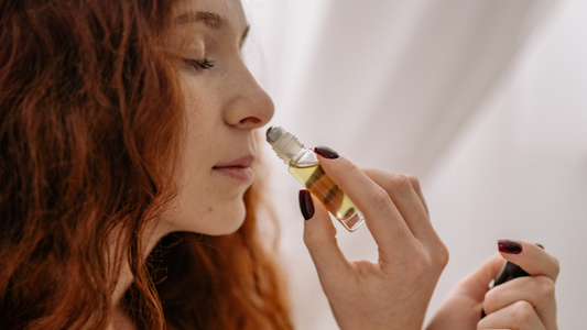 A woman uses essential oil on her skin for aromatherapy
