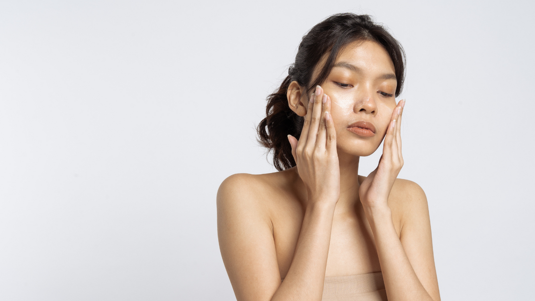 A woman applies skincare to her face