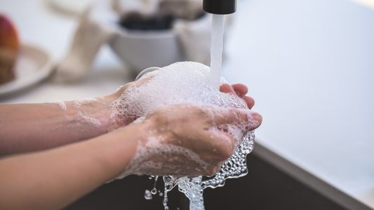 A woman washes her hands with bar soap