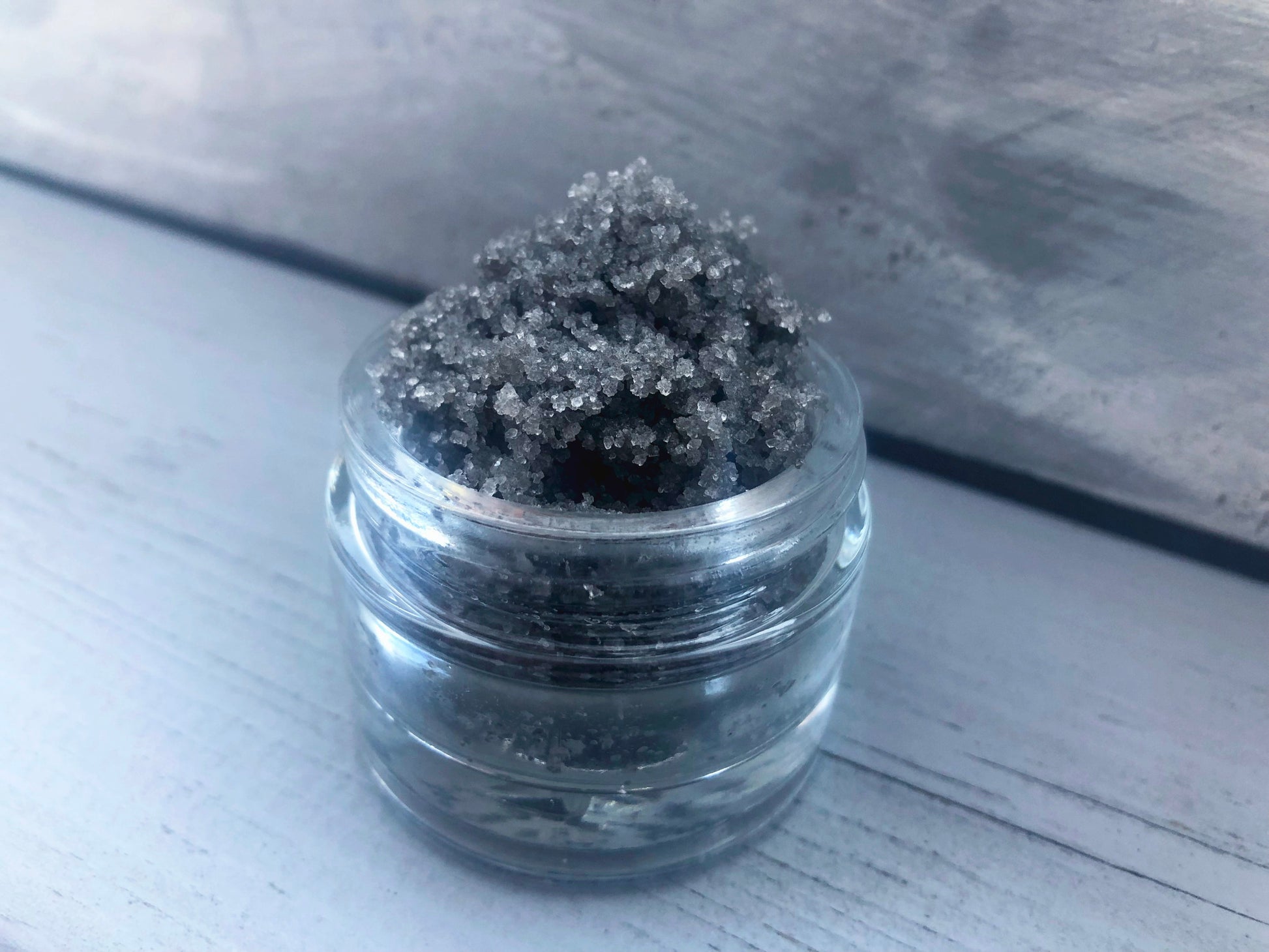 Salted Caramel grey black sugar lip scrub used for exfoliating in a glass jar