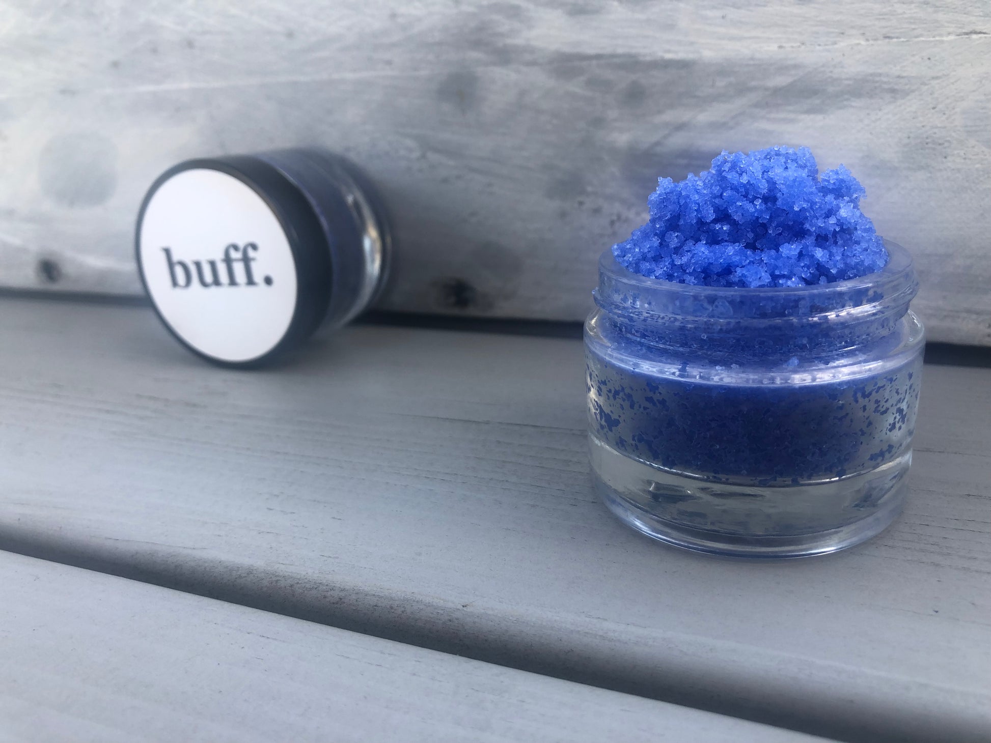 Blue bubblegum sugar lip scrub used for exfoliating in a glass jar
